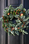 Wintry wreath of fir branches, berries, pine cones and crab apples