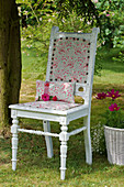 Alter Stuhl neu lackiert und frisch bezogen im Garten