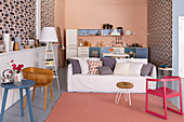 Offener Wohnraum im Stilmix mit grafischer Mustertapete und Küchenzeile vor rosafarbener Stirnwand