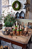 Ländliche Adventsdekoration mit Kerzen in Blechdosen und Gesteck aus Zweigen