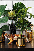 Leopard figurine and exotic plants in golden cache pots
