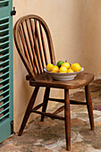 Lemons in a bowl on a wooden chair