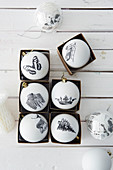 Christmas baubles hand-decorated with black-and-white decoupage motifs