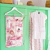 Hand-sewn organiser made from toile-de-jouy fabric hanging on wardrobe