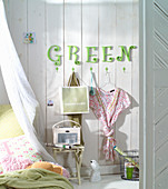 Grüne Buchstaben an der Wand über der Garderobe im Schlafzimmer
