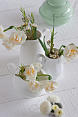 Narcissus and Australian waxflowers in white milk jugs