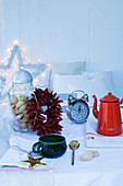 Wreath of chillies, retro alarm clock and vintage enamel coffee pot on festively set table