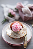 Pink carnation in vintage-style teacup with gilt edge