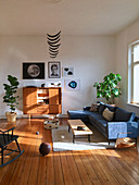 Sonniges Wohnzimmer im Mid Century Stil mit Dielenboden