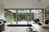 Modern home office with large windows and a view of the inner courtyard