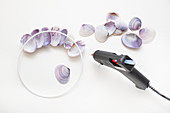 Gluing lilac and white seashells to a metal ring
