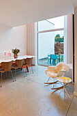 Modernes Esszimmer mit Tulpenstrauß auf dem Tisch und Designerstühlen