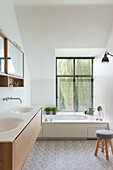 Helles Badezimmer mit Holzwaschtisch und ornamentalen Bodenfliesen