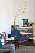 Reading corner with blue armchair, floor lamp and bookshelf in a modern living room