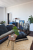 Living room with blue cushions on sofa, monstera, rocking chair and framed artwork