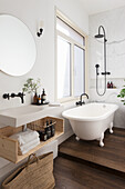 Freestanding bathtub in the bathroom with wooden elements