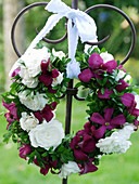 Wreath of clematis 'Mme Julia Correvon' and rose 'Snow Ballet' tied to a heart-shaped decorative stake