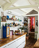 Narrow kitchen with shelves and exposed roof structure
