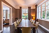 Elegant dining room in shades of brown with long wooden table and leather chairs