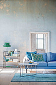Living room in shades of blue and green with distressed wall