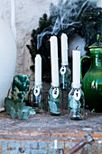 Advent arrangement of white candles in glass bottles