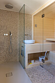 Badezimmer mit begehbarer Dusche mit Mosaikfliesen und integrierter Sauna