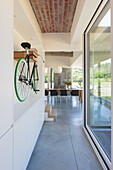 Fahrrad als Wanddekoration in einem modernen Wohnbereich mit Ziegeldecke und Betonboden