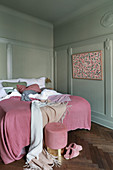 Panelled walls and pink accents in classic bedroom