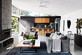 Modern open-plan living room in grey with open-plan kitchen and garden access