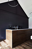 Modern kitchen with black built-in cupboards and dark wood