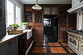 Rustic country-house kitchen with dark wooden cabinets and pantry