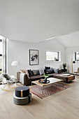 Grey corner sofa and floor cushions in modern, open-plan interior