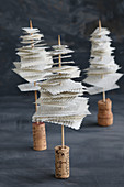 Miniature Christmas trees made form recycles book pages, skewers and corks