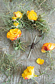 Tie a wreath of rose blossoms and grass