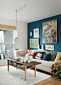 Bildergalerie an blauer Wand im klassischen Wohnzimmer