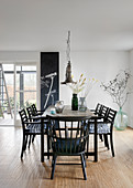 Black chairs around table in dining room with botanical decorations
