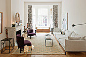 Elegantes Wohnzimmer mit grafisch gemustertem Teppich und Vorhang