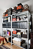 Box files, boxes and baskets in shades of black and brown on metal shelving