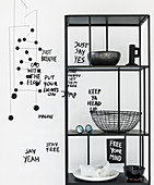 Black-and-white arrangement: mobile, messages on paper and shelves