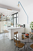 Weiße Küche im skandinavischen Stil mit Retro-Kühlschrank und Essbereich mit Glastisch
