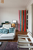 Study area with colorful rolls of decorative fabric and white sofa