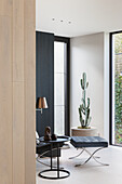 Minimalistisches Wohnzimmer mit Kaktus und Freischwinger-Sessel