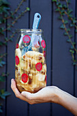 Hand holding jar of homemade apple preserve decorated with red polka-dots
