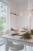 Gedeckter Tisch im Esszimmer in Weiß zu Weihnachten