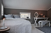 Schlafzimmer unter der Dachschräge in Weiß und Grau