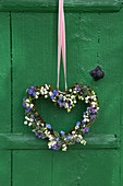Heart-shaped wreath of lily-of-the-valley and forget-me-nots on window shutter