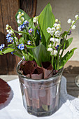 Posies of lily-of-the-valley and forget-me-nots in rolled leaves