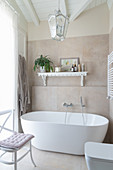 Badezimmer in Weiß und Beige mit frei stehender Badewanne