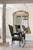 Pair of Louis XV armchairs in white, open-plan living space with oversized gilt-framed mirror