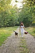 Frau mit Hund beim Waldspaziergang